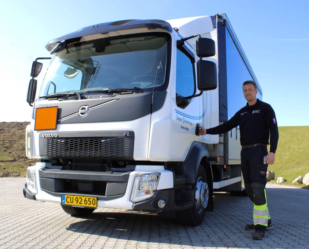 Hvid distributionsbil med chauffør – klar til leverance.